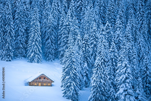 Traditional mountain cabin in winter wonderland in the Alps
