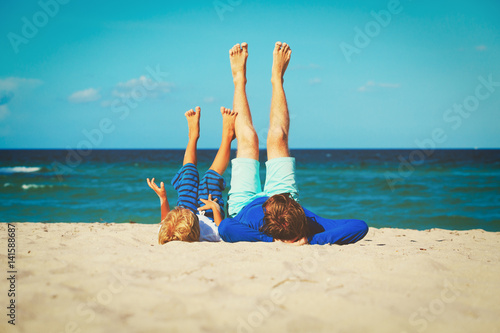 father and little son play on beach