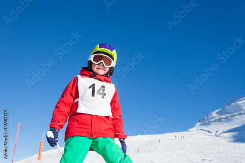 Boy skier in helmet and mask finishing the ride