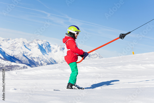 Portrait of boy on button ski lift at sunny day