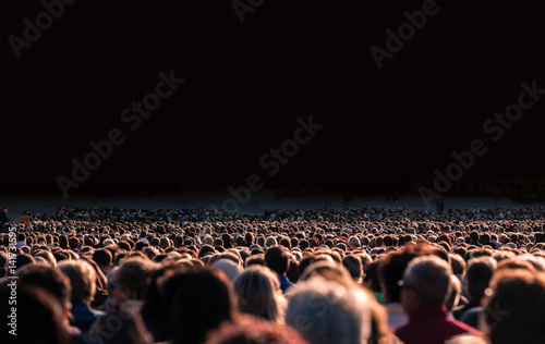 Panoramic photo of large crowd of people. Slow shutter speed motion blur.