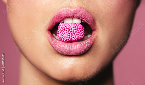 Beautiful pink lips with a piece of candy
