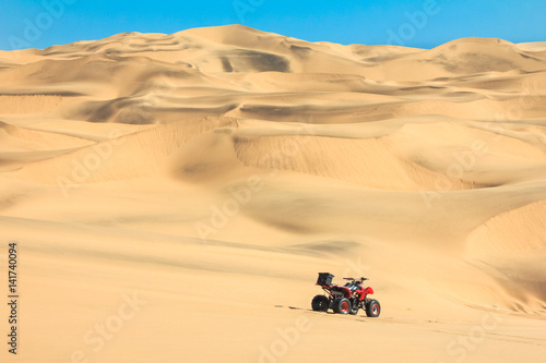 Quad driving in sand desert. ATV in middle of nowhere.