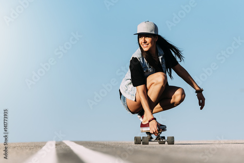 Beautiful skater woman riding on her longboard.