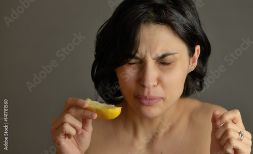 Woman eating lemon and making silly faces