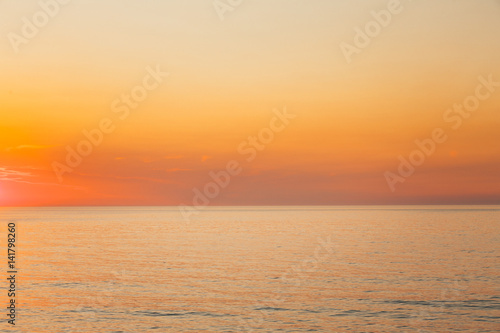 Calm Sea Or Ocean And Yellow Clear Sunset Or Sunrise Sky Background