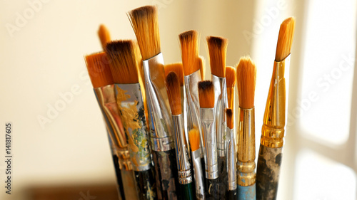 Artist paintbrushes. Set of different artist paint brushes in old crock close-up. Art studio concept. Selective focus footage with shallow DOF.