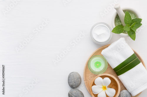 Spa concept with salt, mint, lotion, towel, candle, stone and flower on white background