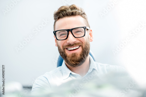 Handsome businessman with great smile sitting on the dental chair