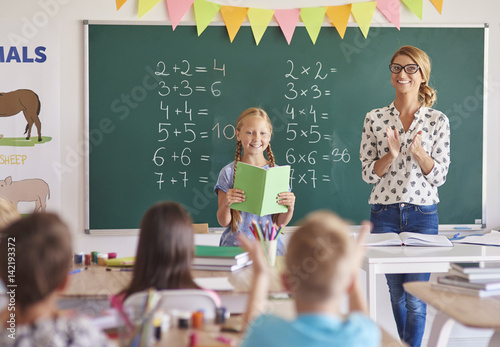 Girl student with clapping teacher .