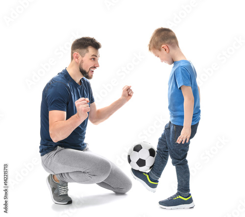 Handsome man and his son with soccer ball on white background