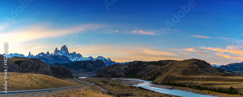 The road approaching the town of El Chalten with famous Patagonia mountains in the background at golden hour