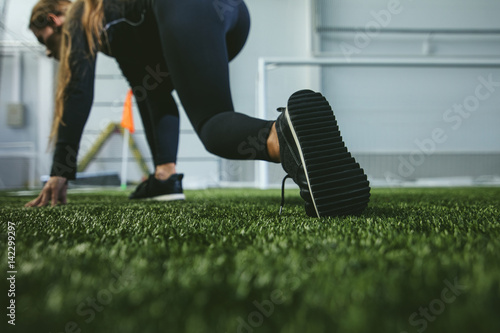 Young woman in sportswear is engaged in the sports stadium closeup of feet
