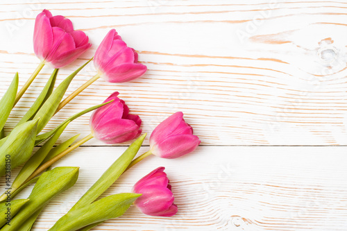 Свежие розовые тюльпаны на белом деревянном фоне