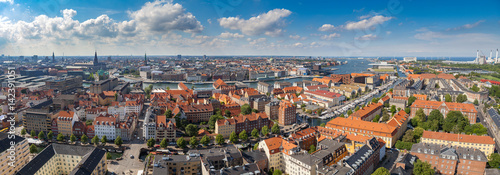 Wide panoramic aerial view of Copenhagen red roofs and canal.