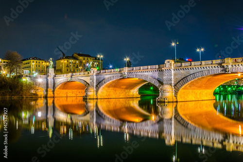 night view of the ponte umberto I bridge over river po with cityscape of torino, italy.