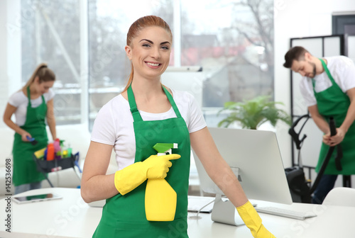 Young female cleaner at work in office