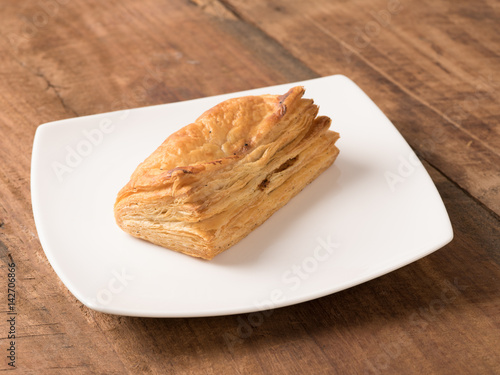 veg puffs served in a white plate on wooden background