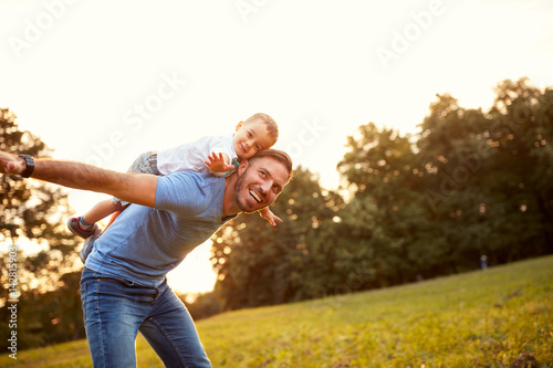 Father piggyback his son outside