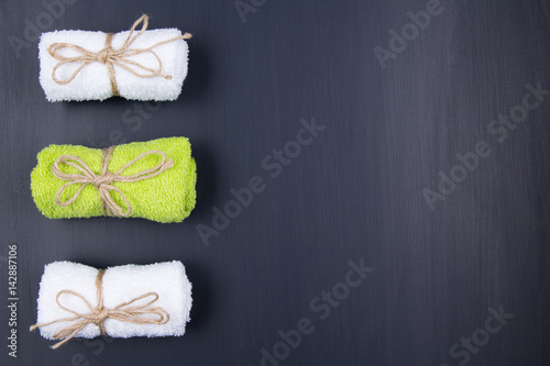 Three different towels are lying on a black background