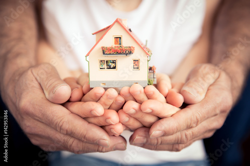 Family holding house in hands