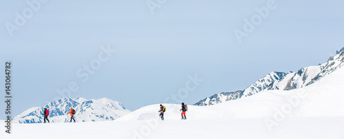 Skiers walking on snow covered mountain ranges