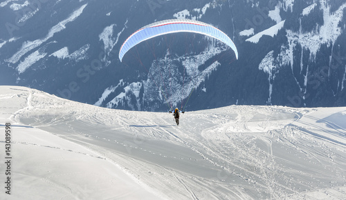The pilot begins flight on a paraplane with a mountain-skiing slope of Penken - Mayrhofen, Austria