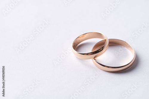 Closeup of Two classical gold wedding rings isolated on white background with copy space. Love and marriage proposal concept.