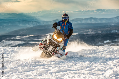 Rider on the snowmobile in the mountains. active drive