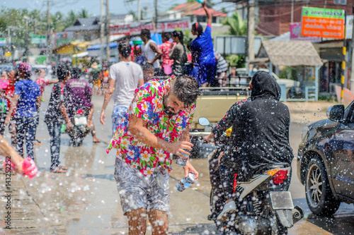 Thais and tourists shooting water guns, pour water on each other, having fun at Songkran festival, the traditional Thai New Year