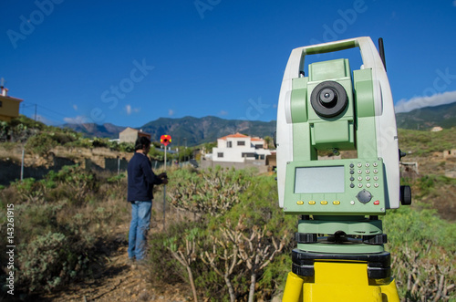 Modern surveyor equipment, theodolite or tacheometer used in surveying and building construction for precise measurement. Total station outdoor at construction site.