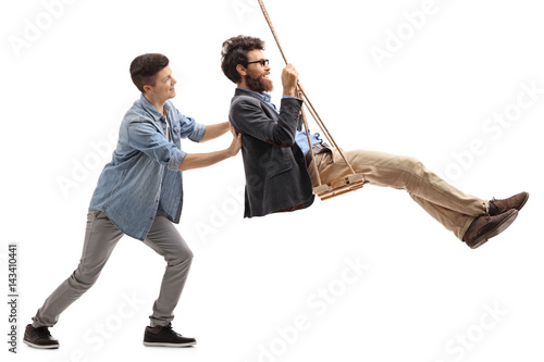 Son pushing his father on a swing