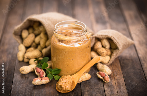 Peanut butter and peanuts on the wooden table