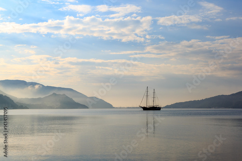 Vintage boat in misty weather with reflection