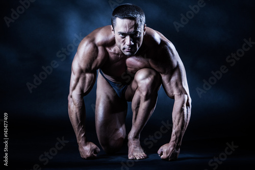 The athlete at the start. Big muscles. A man with large muscles. Body-building.