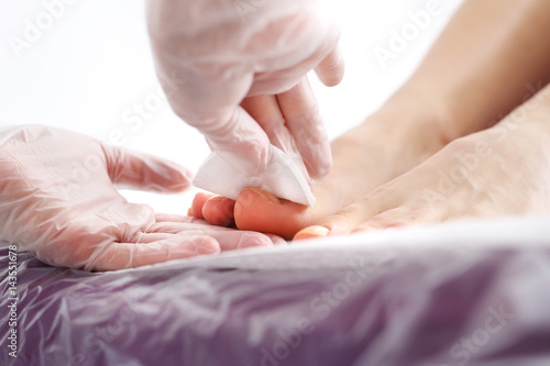 Pedicure w salonie kosmetycznym. Zabieg pielęgnacyjny stóp i paznokci, kobieta u kosmetyczki na zabiegu pedicure.