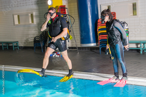 teen girl gets scuba diving lesson from an instructor in a swimming pool scuba diving course