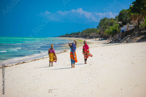 Three women walking on the beach in Jambiani, Zanzibar island, Tanzania