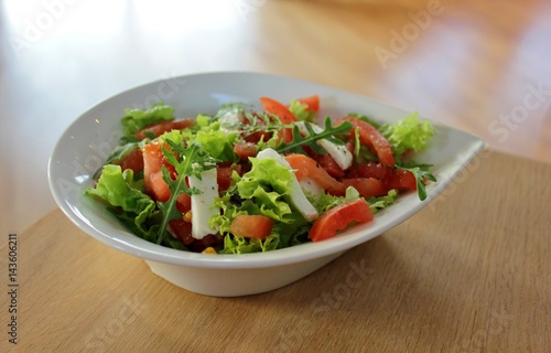 Bowl with Italian caprese salad with lettuce, mozzarella and tomato