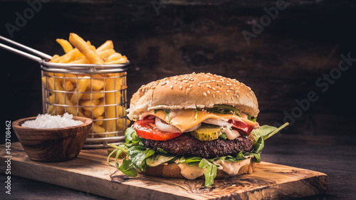 Burger with fries on wooden