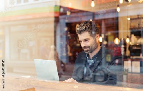 man working on a digital project in a cafe