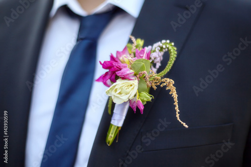 Colorful wedding boutonniere on suit of groom