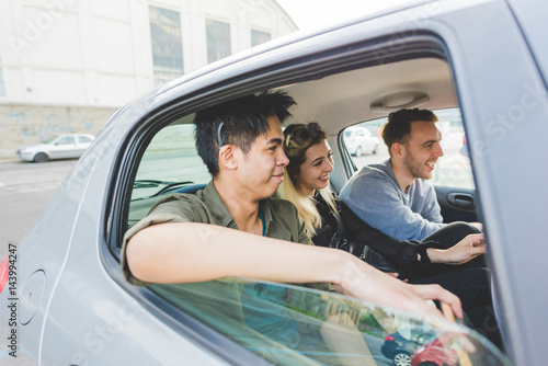 Group of friends multiethnic millennials view from automobile window traveling by car - togetherness, interaction, car sharing concept