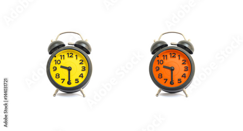Closeup yellow alarm clock and orange alarm clock for decorate show a half past nine o'clock or 9:30 a.m. isolated on white background