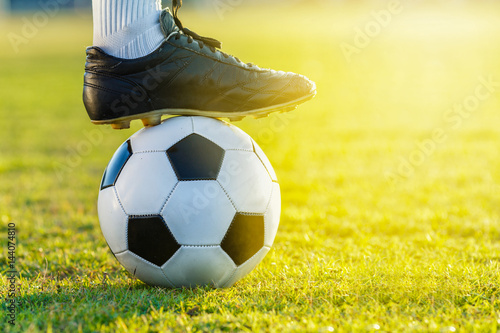 feet of soccer football player standing with the ball