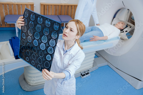 Beautiful female radiologist looking at the MRI scan images