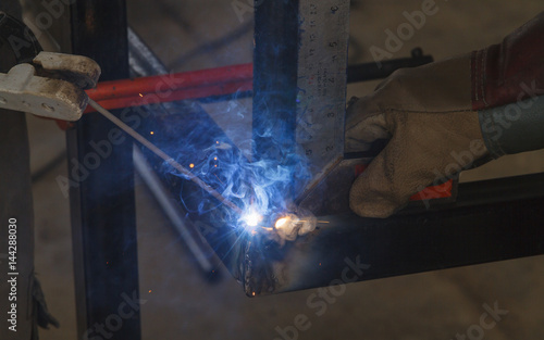 Shield metal arc welding welding and C-clamp in fabrication work shop.