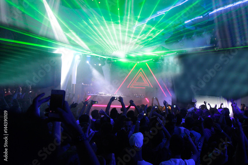 Night club dj party people enjoy of music dancing sound with colorful light with Smoke Machine and lights show. Hands up in the earth.