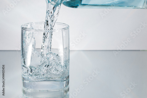 Decanter filling in glass of water splash