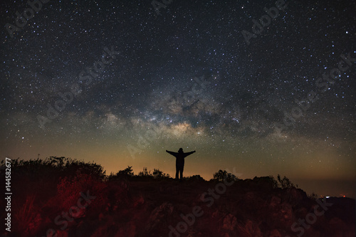 Landscape with milky way, Night sky with stars and silhouette of a standing man on Doi Luang Chiang Dao mountain, Long exposure photograph, with grain